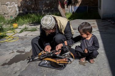 Ehsanullah bichonne son AK-47, son outil de travail quand il part en mission en province. Avec Muhammad, 4 ans, son seul fils.